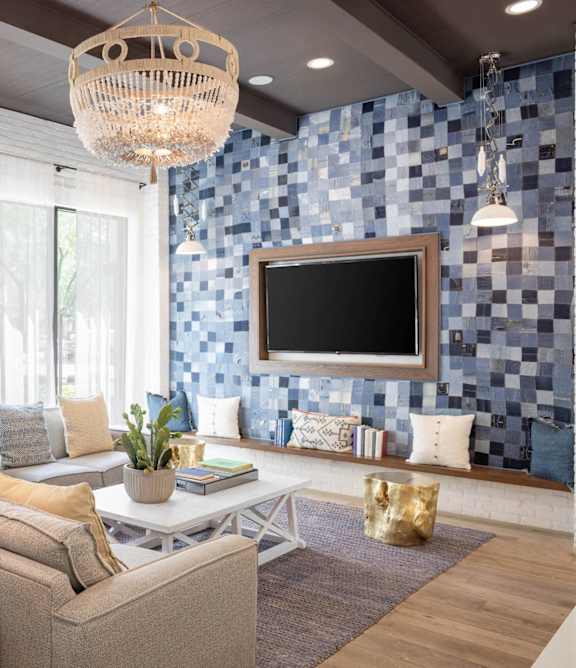 A modern living room with a large sofa, a wooden coffee table, and a chandelier.