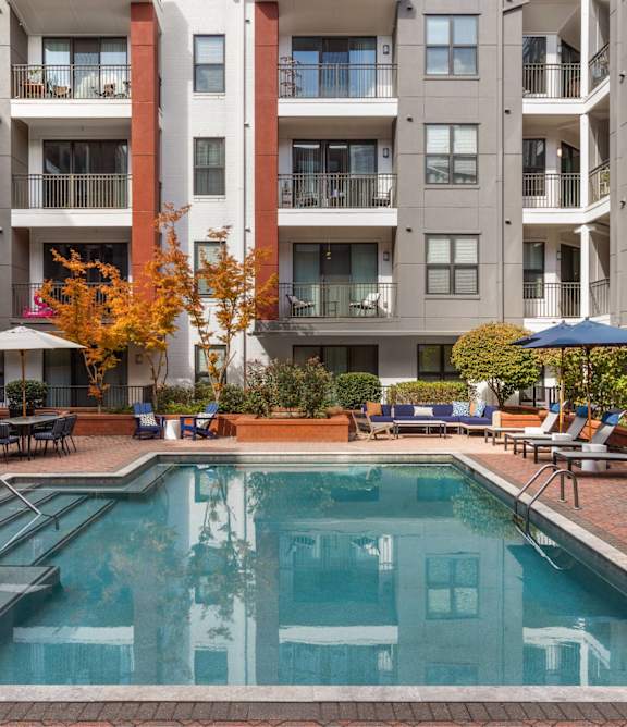 A swimming pool in front of apartment buildings.