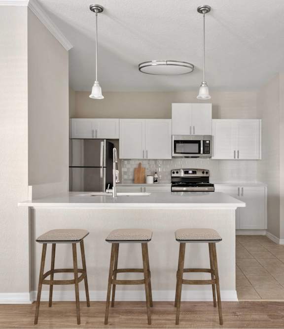 A kitchen with a white countertop and bar stools.