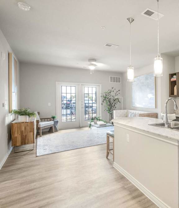 an open kitchen and living room with a large island and stainless steel appliances