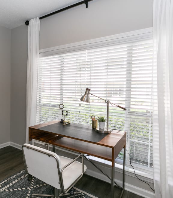 a home office with a large window with white blinds and a desk and chair at Willowest in Collier Hills in Georgia 30318