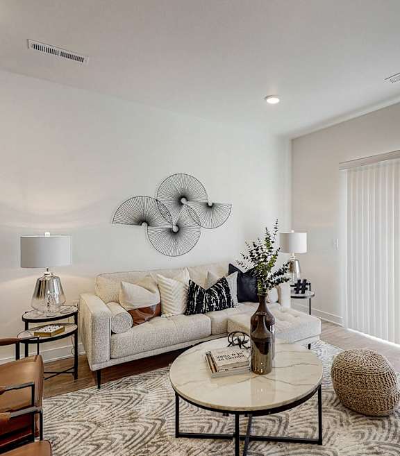 A modern living room with a large sofa, a coffee table, and a large abstract wall art. at Centennial Crossing, Waukee, 50263