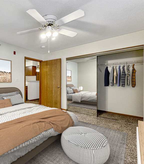 A bedroom with a large bed and a ceiling fan. at Somerset Apartments, Des Moines, IA, 50315