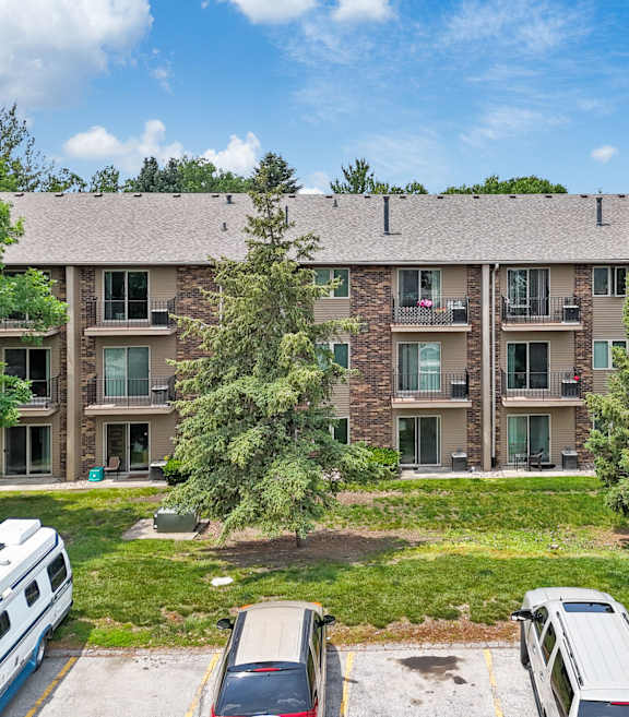 A large apartment complex with a parking lot in front.