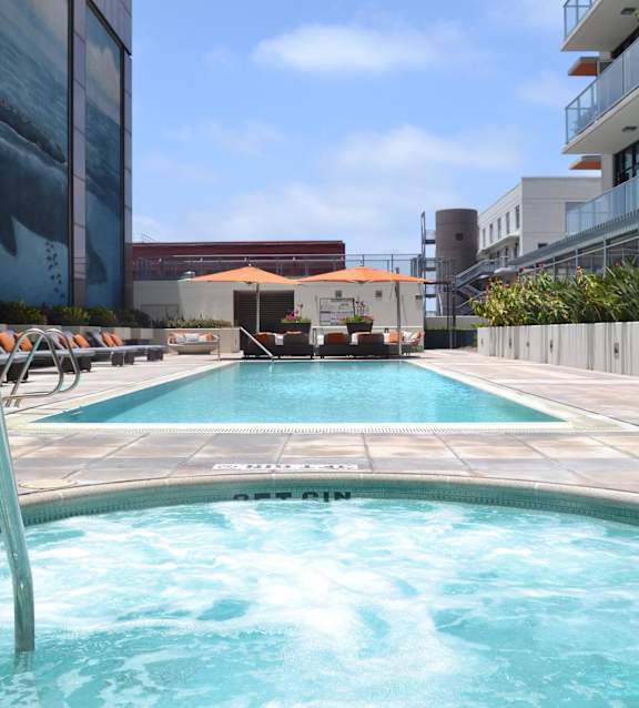 A swimming pool with lounge chairs and the word "REACH" repeated across the image.
