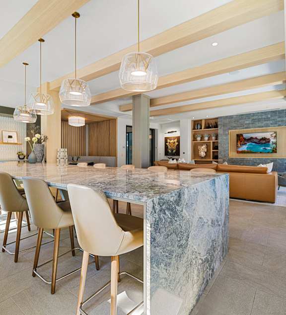 Entertaining space with a dramatic stone island, chic pendant lighting, and seamless flow into lounge seating