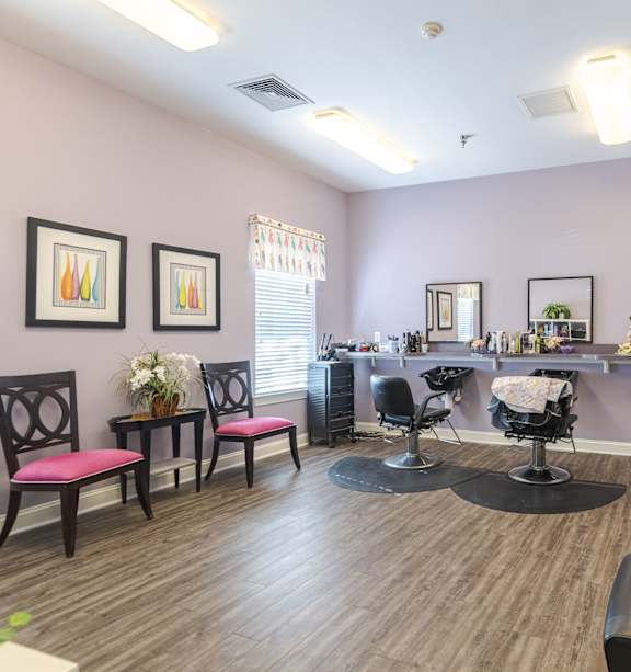 A hair salon with chairs and a mirror.at The Gardens of Stafford, Stafford, VA 22556