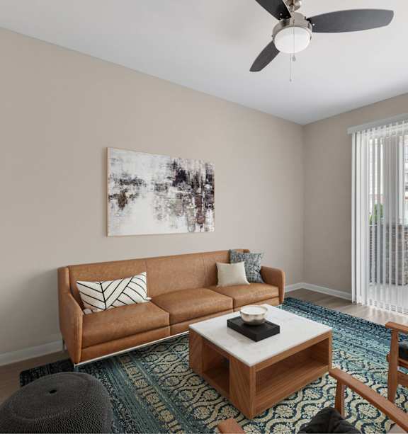 A living room with a brown couch, a coffee table, and a ceiling fan.