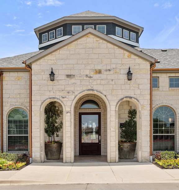 A large building with a stone facade and a central arched entrance.