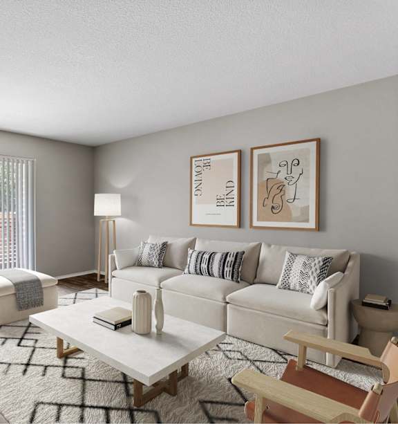 A living room with a white couch, a wooden chair, a coffee table, and pictures on the wall.