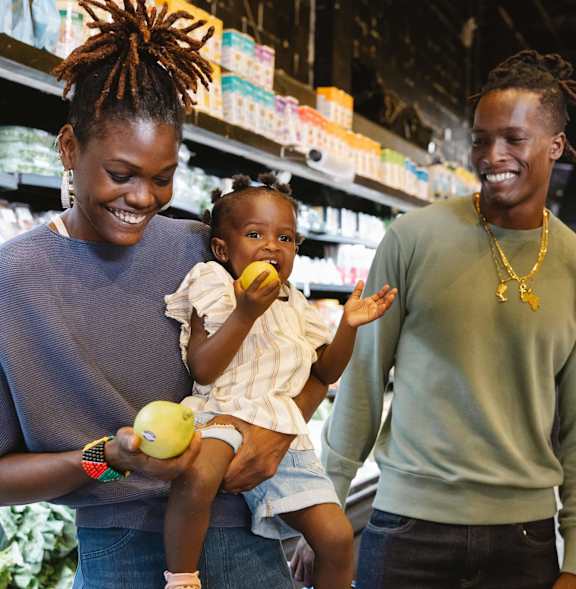 A woman and a man are shopping with a child in a grocery store.