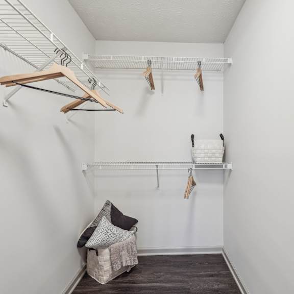 a walk in closet with shelves and hooks and a chair at Gwinnett Pointe in Norcross, Georgia 30093