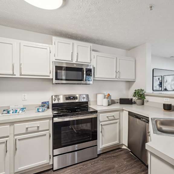 a kitchen with stainless steel appliances and white cabinets at Gwinnett Pointe in Georgia 30093