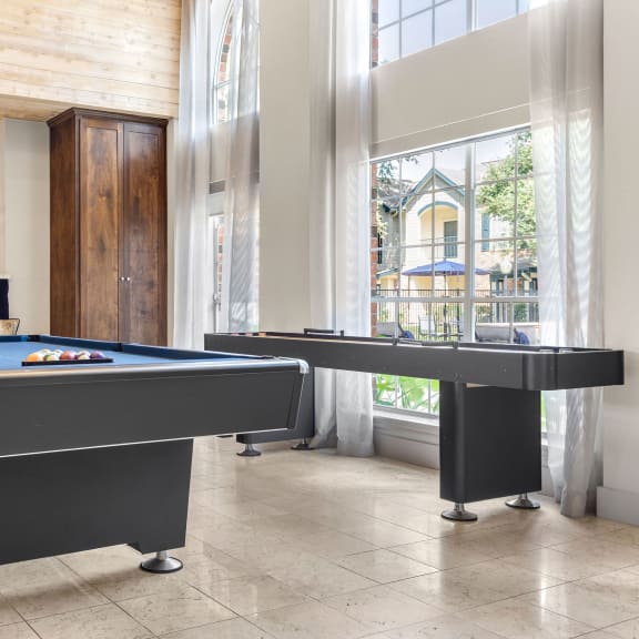 two pool tables in a living room with large windows at Aston at Cinco Ranch in Texas 77450