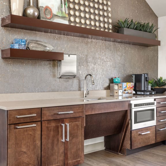 a kitchen with wooden cabinets and a sink and a stove at Arcadia Apartments, Centennial, CO 80112