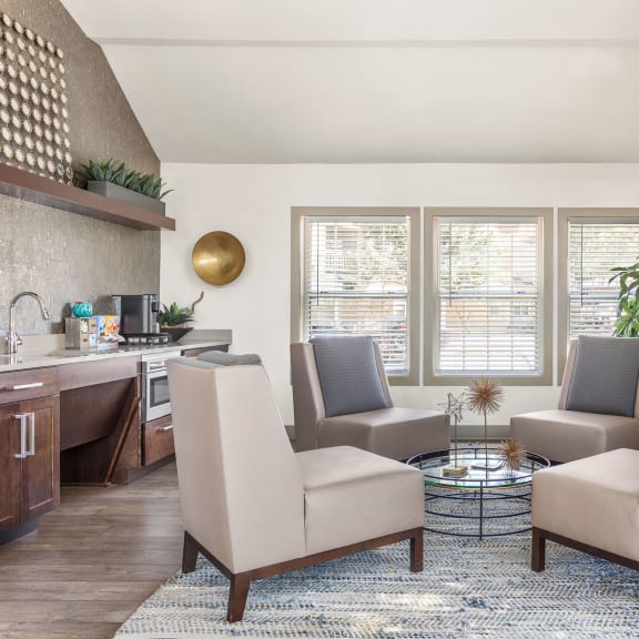 a living room with chairs and a table and a fireplace at Arcadia Apartments, Colorado, 80112