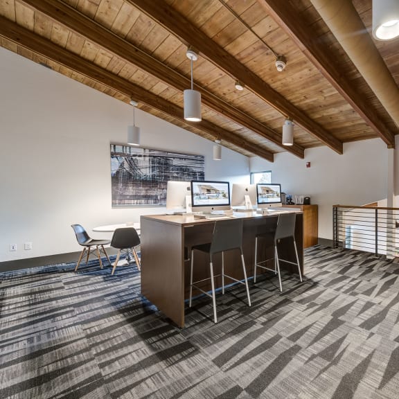 an office space with a desk and chairs and a bar with chairs at Ashford Belmar Apartments, Lakewood, Colorado