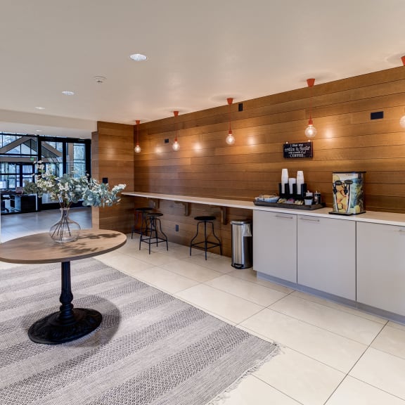 a kitchen with a coffee table and a refrigerator at Ashford Belmar Apartments, Lakewood, CO