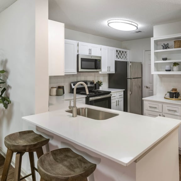 an open kitchen with a white counter top and a sink at Roswell Village in Roswell, GA 30075