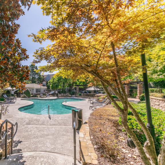 a swimming pool with trees and benches next to it at Deerfield Village, Alpharetta