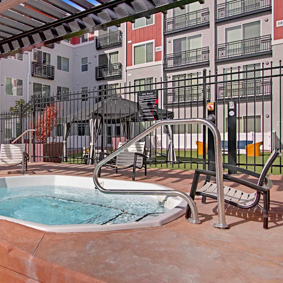 A jacuzzi pool with an apartment building in the background at the Ritz Classic Apartment Homes. 
