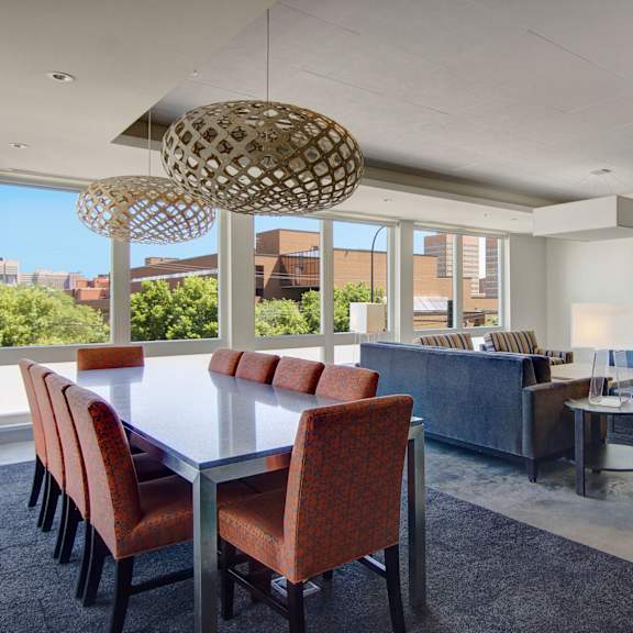 7West resident clubhouse with a table and chairs, couches, and a TV. 