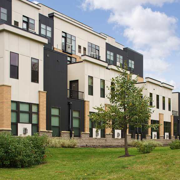 The exterior of the apartments at Marbella on Dean, showing black and white exterior walls, windows, and green space. 