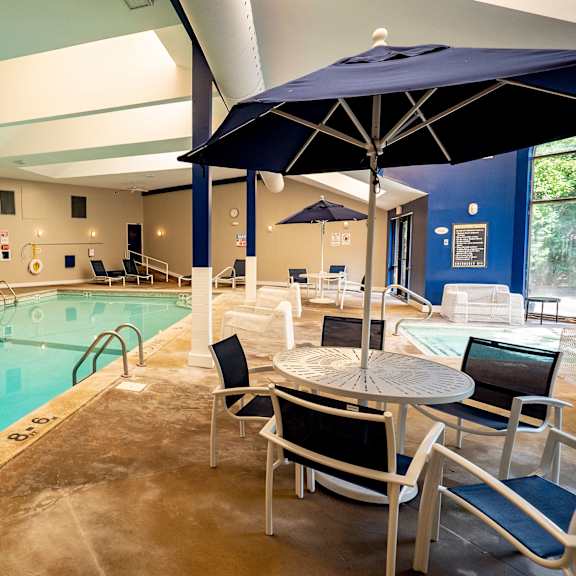 a swimming pool with tables and chairs and umbrellas at Plymouth Square