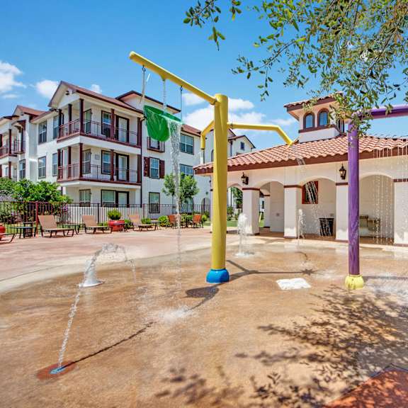 Splash pad at Andalucia Villas with splash pad facilities and pool chairs in the background. 
