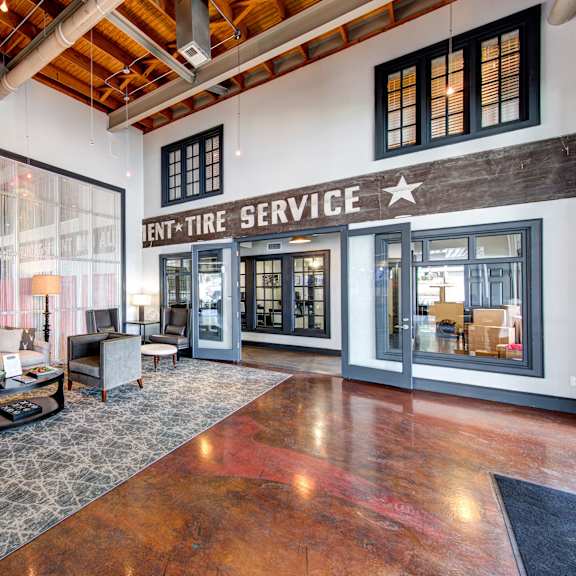 The lobby at Firestone at West 7th with a coffee table, plush chairs, and a couch. 