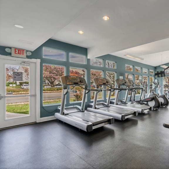 a gym with cardio equipment and windows with a view of the street at Misty Ridge Apartments, Woodbridge, 22191