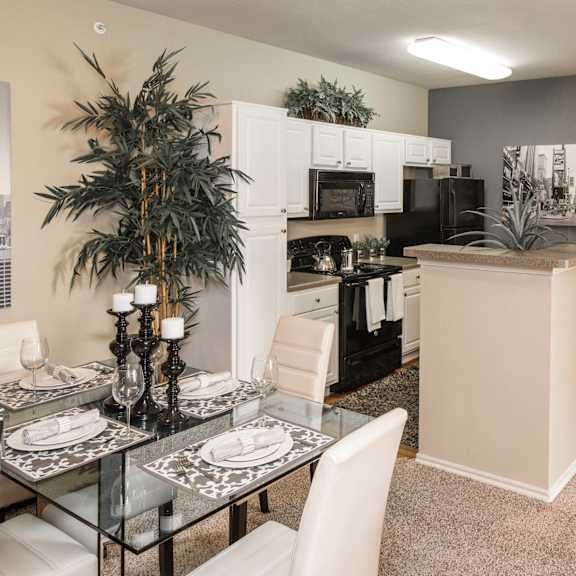 A modern kitchen with a glass table set for two. at Infinity on Sunnyvale Apartments , Mesquite, 75150