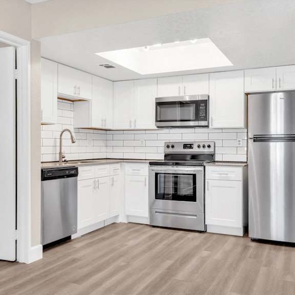 A kitchen with white cabinets and stainless steel appliances.