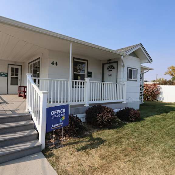 the front of a white house with a porch and a no parking sign at Country Lane, Cheyenne, Wyoming