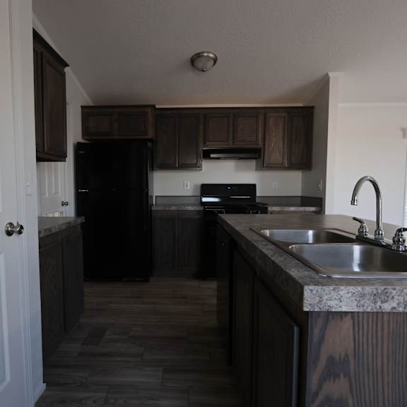 a kitchen with dark cabinets and a sink at Horizon MHC, Rock Springs, WY 82901