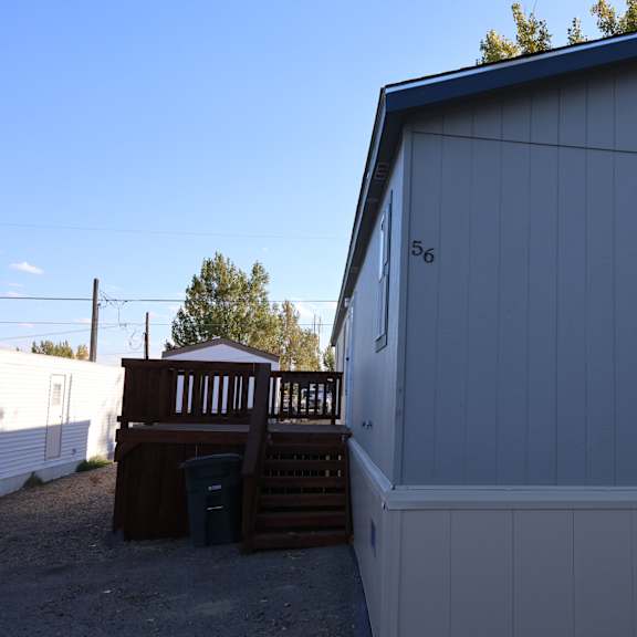 the exterior of a white building with a deck and a window at Horizon MHC, Rock Springs, WY 82901