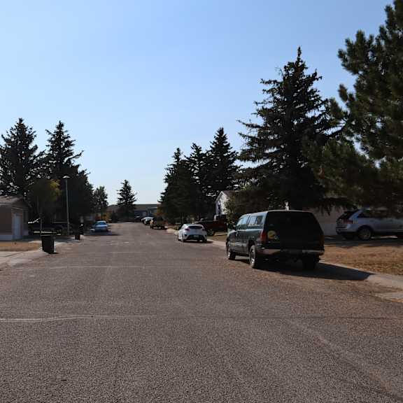 a street with cars parked on the side of it and trees at Kimberly Village, Cheyenne, Wyoming
