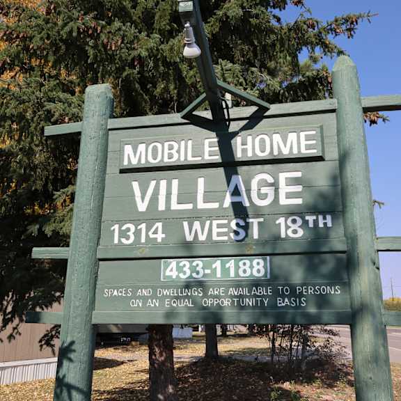 a sign for mobile home village in front of a tree at Mobile Home Village, Cheyenne, Wyoming