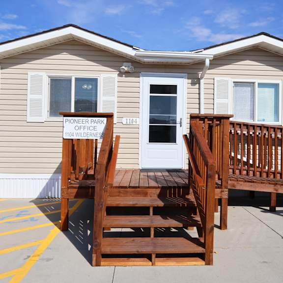 a yellow tiny house with a wooden deck in front of it at Pioneer Park, Green River, Wyoming