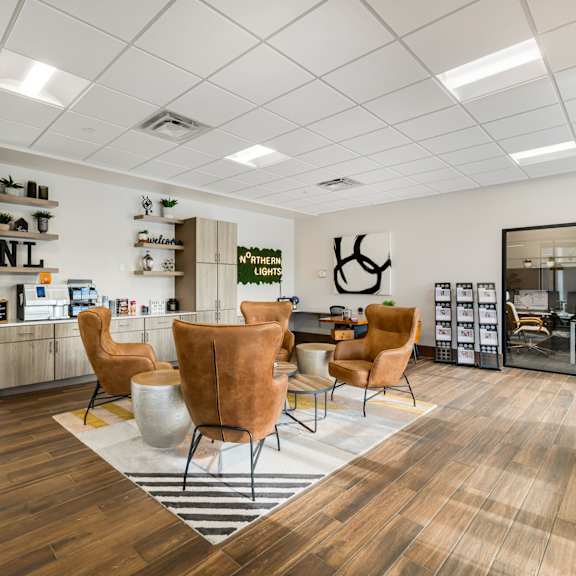 the waiting room of a salon with chairs and a table at Northern Lights a Lifestyle-Driven Community, West Fargo, North Dakota