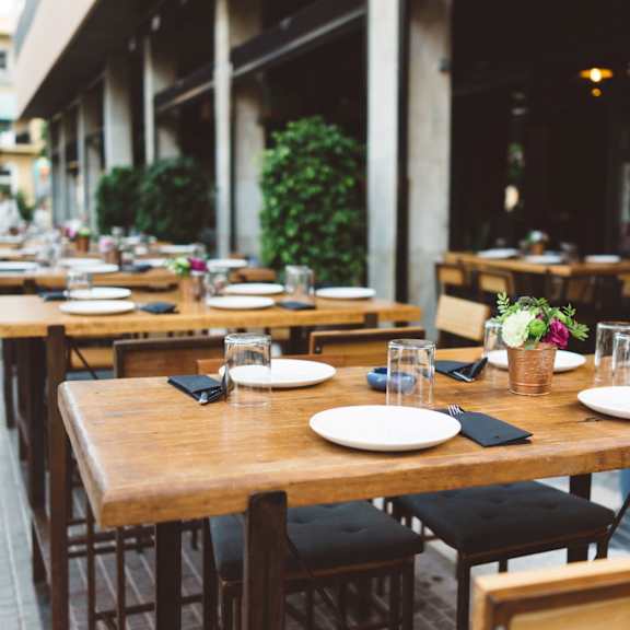 an empty restaurant with wooden tables and chairs