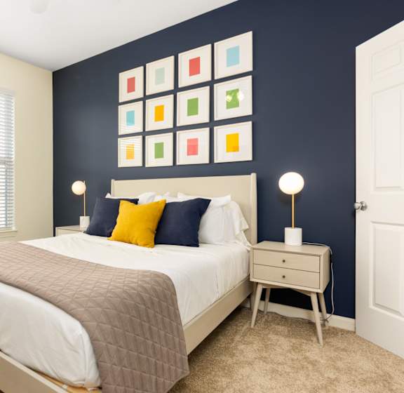 a bedroom with a bed and a blue wall and a window