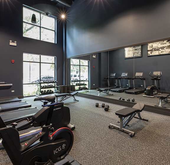 A gym with treadmills, exercise bikes, and weights.