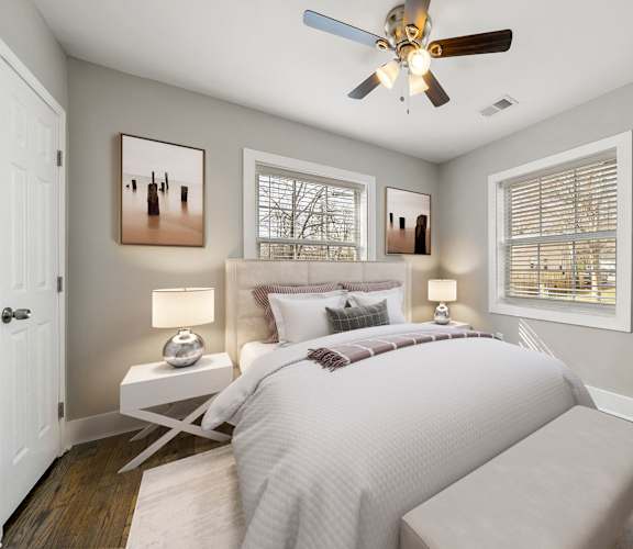 A bedroom with a bed, a ceiling fan, and two lamps at Balfour Marietta Apartments, Marietta, GA, 30060