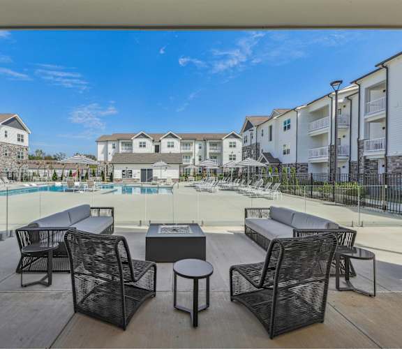 an outdoor patio with chairs and tables next to a pool