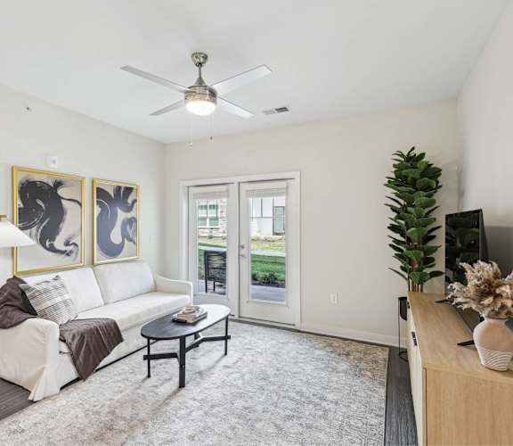 a living room with a white couch and a ceiling fan