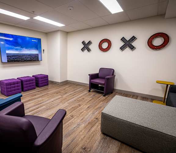 a waiting room with purple chairs and a tv