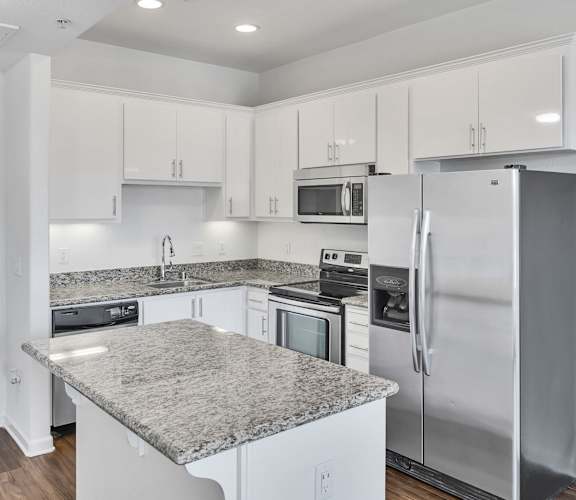 a kitchen with white cabinets and stainless steel appliances and granite counter tops