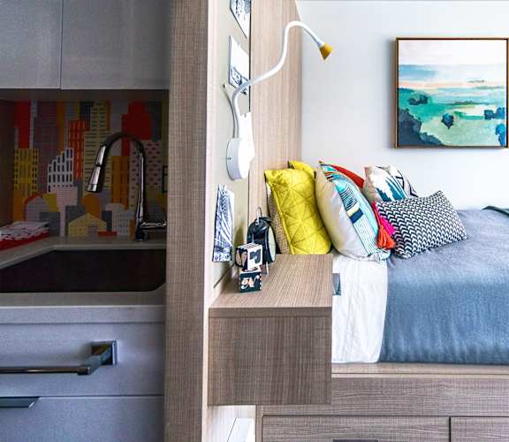 A bedroom with a bed, pillows, and a painting on the wall at 28Grand, Detroit, MI