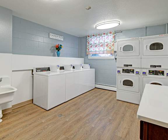 A laundry room with washer and dryer and a sink at Century Plaza Apartments. 